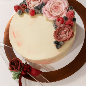 Elegant wedding cake with pink buttercream roses and sugared berries by Sweet Sensation bakery in Sharon, PA
